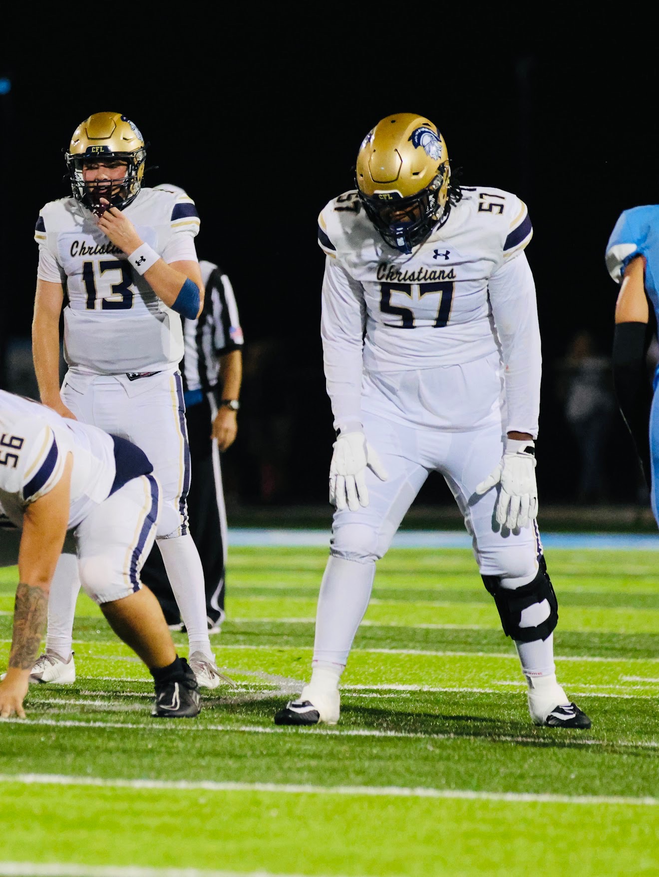 Kayden Hamilton number 57 preparing at the line in white uniform